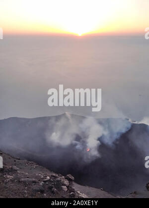 Fumoso scenario del cratere di vulcano Stromboli vicino la Sicilia al tempo di sera Foto Stock