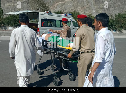 Chilas, Paksitan. 22 settembre 2019. Foto scattata con il cellulare mostra persone salvataggio di un uomo ferito dopo un incidente stradale nel nord del Pakistan, Sett. 22, 2019. Almeno 26 persone sono state uccise e 19 altri feriti quando un autobus passeggeri si è schiantato in una collina nel nord del Pakistan a domenica, un ufficiale di polizia ha detto. (Str/Xinhua) Credito: Xinhua/Alamy Live News Foto Stock