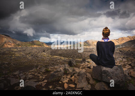 Donna escursionista che guarda la tempesta vista sul sentiero laugavegur, Islanda Foto Stock