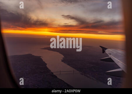 Ala di aeroplano vista di Lisbona durante il tramonto Foto Stock