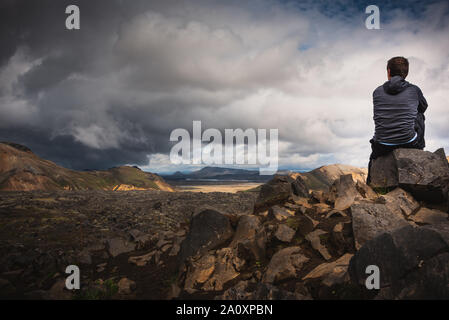 Escursionista ammirando la vista della tempesta sul sentiero laugavegur, Landmannalaugar a Porsmoerk Islanda Foto Stock