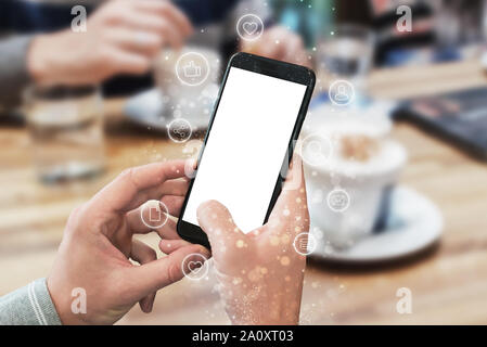 Telefono in mani di uomo con display isolato per mockup. Internet delle cose sulle icone accanto a. Concetto di utilizzando le tecnologie mobili. Foto Stock