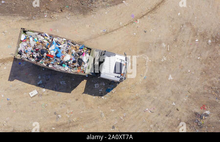 Caricato Immondizia camion scarico in una discarica comunale, superiore dell'antenna verso il basso Foto Stock