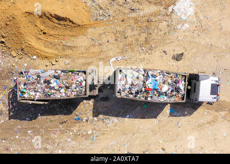 Caricato Immondizia camion scarico in una discarica comunale, superiore dell'antenna verso il basso Foto Stock