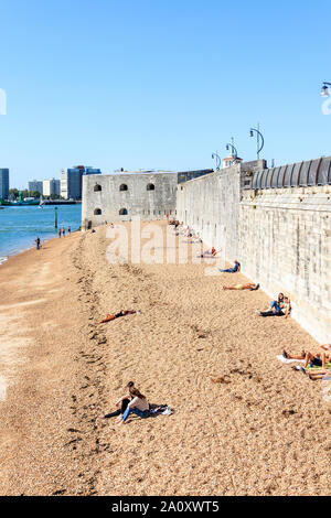 Persone sole stessi sulla spiaggia a Portsmouth Porto, la torre rotonda in background, Portsmouth, Regno Unito Foto Stock