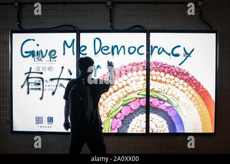 Il dimostratore rendendo un graffiti durante le proteste.manifestanti continuano a dimostrare attraverso Hong Kong per la quindicesima settimana consecutiva. La dimostrazione si sono tenute all'interno di un centro commerciale in Yuen Long contro il governo. Foto Stock