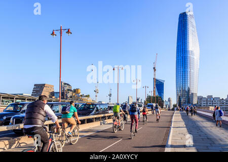 I ciclisti e automobili su Blackfriars Bridge nelle ore di punta, il vaso (n. 1 Blackfriars) in background, London, Regno Unito Foto Stock