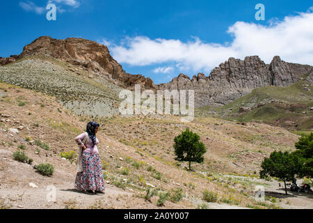 Dogubayazıt: Curdo donna in abiti tradizionali sul sentiero vicino al castello di vecchi Beyazit, il Ishak Pasha Palace e Eski Bayezid Cami moschea Foto Stock