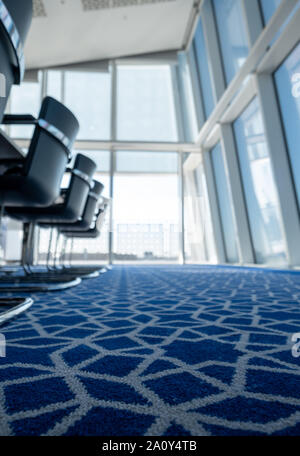 Luce, sunny boardroom con tubolare piegato sedie in acciaio e tappeti blu con disegno geometrico, all'Aga Khan Centro, Kings Cross, London, Regno Unito. Foto Stock