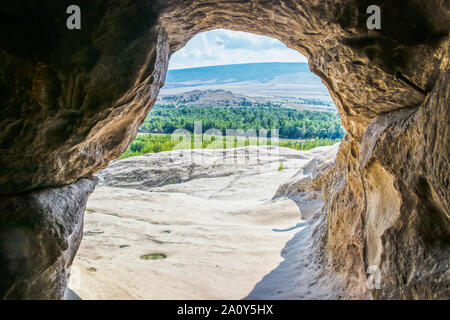 Incorniciato vista della vallata dall'interno di Uplistsikhe Grotta Town - Antica pre-rock cristiano-città squadrate e monastero in Georgia in Europa orientale Foto Stock