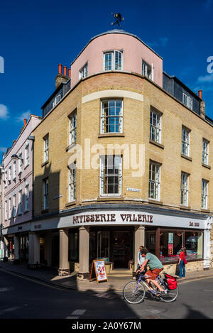 Patisserie Valerie - un ciclista passa Patisserie Valerie sull'angolo di una fila di negozi in Bridge Street, centro di Cambridge Regno Unito Foto Stock