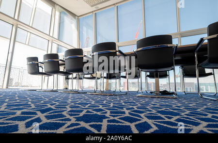 Luce, sunny boardroom con tubolare piegato sedie in acciaio e tappeti blu con disegno geometrico, all'Aga Khan Centro, Kings Cross, London, Regno Unito. Foto Stock