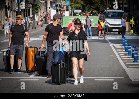 Un gruppo di turisti che arrivano in città sono visti a piedi con le loro valigie attraverso la zona chiusa alla circolazione dei veicoli in Via Laietana per la celebrazione del mondo Car-Free giorno.Barcelona celebra la Giornata mondiale senza auto da condizionare una delle arterie principali della città per l'impiego di cittadini con diverse realtà culturali attività ricreative. Migliaia di cittadini hanno goduto di un giorno di festa in Via Laietana con la circolazione completamente chiusa per veicoli. Foto Stock