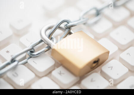 Concetto di sicurezza con lucchetto in metallo e la catena sulla tastiera del computer Foto Stock