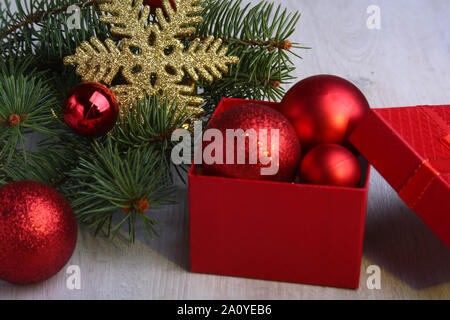 Regali di natale. Decorazione di Natale con regali e sfera rossa con rami di abete Foto Stock