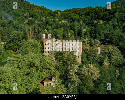 In rovina la scuola ricoperta in ghost città mineraria Akarmara, le conseguenze di una guerra in Abkhazia, vista aerea da fuco. Foto Stock