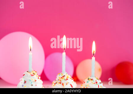 Tortini di compleanno con le candele accese Foto Stock