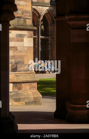 Gli studenti godono del sole nel quadrilatero orientale dell'edificio principale della Glasgow University Foto Stock