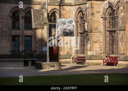 Uno studente gode del sole mentre studiano in Glasgow University a ovest del quadrangolo Foto Stock