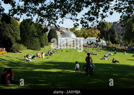 La folla godendo il sole autunnale nel Giardino Botanico nel west end di Glasgow.