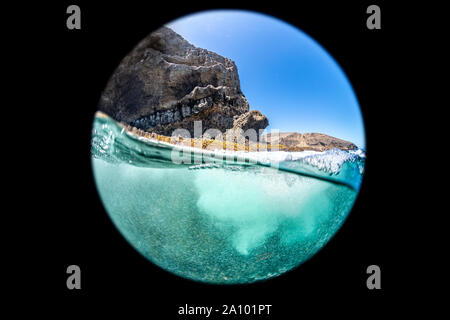 Immagine ripresa con una lente circolare mostra un over in vista dell'acqua grezza che circonda una barriera corallina su Santa Barbara Island in California. Foto Stock