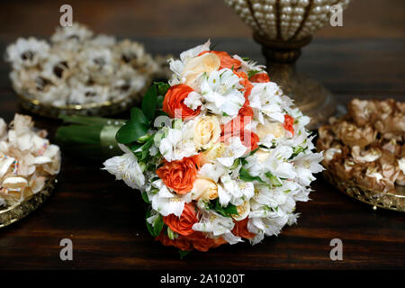 Wedding bouquet di rose e gustoso matrimonio caramella sul tavolo di legno Foto Stock