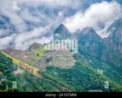 Una spettacolare ad alto angolo di visione di Machu Picchu, circondato da nebbia e nuvole di mattina, scattato dalla Porta del Sole. Foto Stock