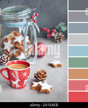 Colore tavolozza corrispondente da foto di vetro cookie jar con star gingerbread cookie decorato con nastro e berry e una tazza di caffè Foto Stock