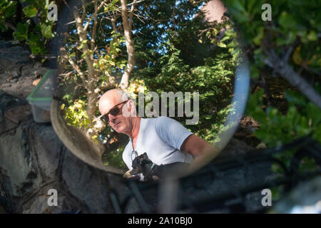 La riflessione di un uomo può essere visto in questa motocicletta specchio in San Rafael, CA. Foto Stock