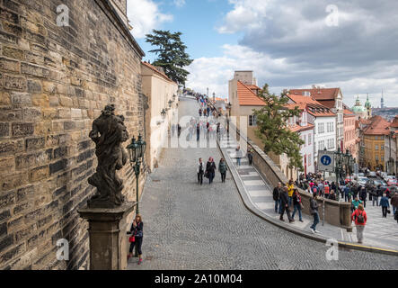 I turisti su scenic via Nerudova e Ke Hradu facendo la loro strada in salita verso il famoso Castello di Praga, Hradcany, Mala Strana, Praga, Repubblica Ceca Foto Stock