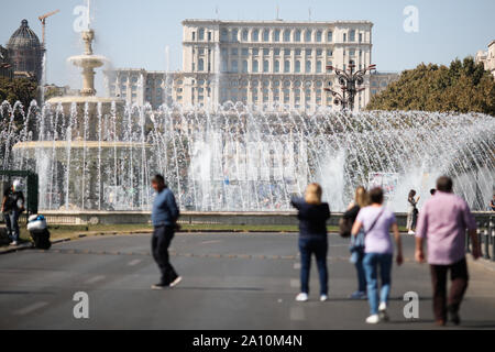 Bucarest, Romania - 22 Settembre 2019: la gente a piedi su un vuoto di boulevard con il Palazzo del Parlamento sullo sfondo al centro di Bucarest. Foto Stock