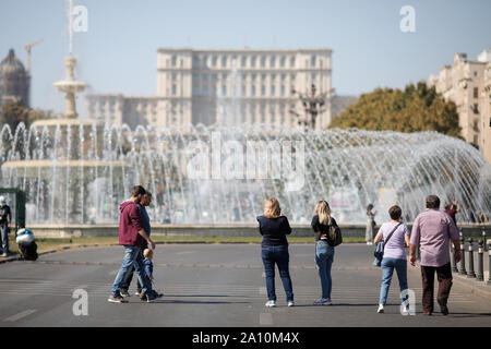 Bucarest, Romania - 22 Settembre 2019: la gente a piedi su un vuoto di boulevard con il Palazzo del Parlamento sullo sfondo al centro di Bucarest. Foto Stock