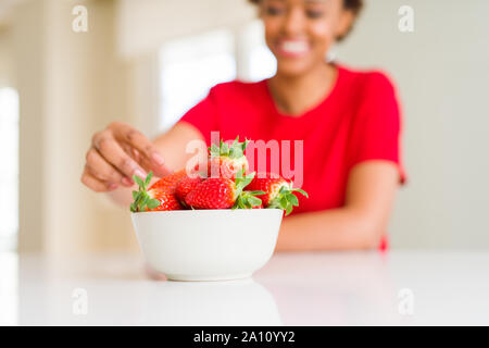 Close up della giovane donna di mangiare fragole fresche Foto Stock