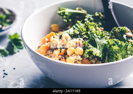 Vegan stufato con ceci, patata dolce e kale in una ciotola bianco. Foto Stock