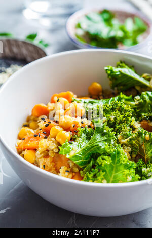 Vegan stufato con ceci, patata dolce e kale in una ciotola bianco. Foto Stock