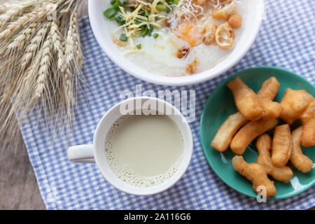 Breakfase pasto. Congee o riso porridge di carne macinata di maiale, uovo sodo con latte di soia e il cinese fritte doppio bastone di pasta Foto Stock