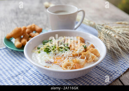 Breakfase pasto. Congee o riso porridge di carne macinata di maiale, uovo sodo con latte di soia e il cinese fritte doppio bastone di pasta Foto Stock