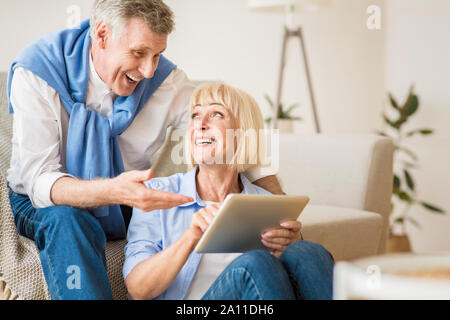 Lo shopping online. Felice coppia di anziani utilizzando tablet Foto Stock