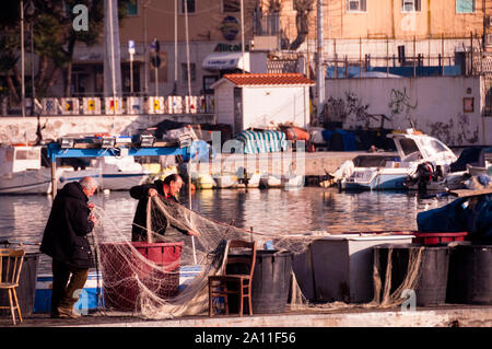 Preparazione di reti da pesca ad Anzio, in Italia, oggi località balneare, un tempo luogo di sbarchi alleati durante la seconda guerra mondiale Foto Stock