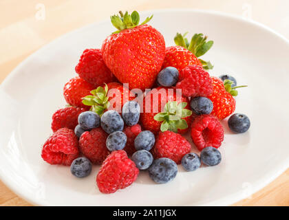 Pila di frutti di bosco misti su una piastra bianca Foto Stock