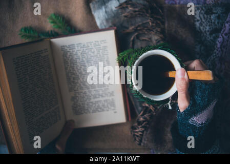 Ragazza beve caffè e legge il libro Foto Stock