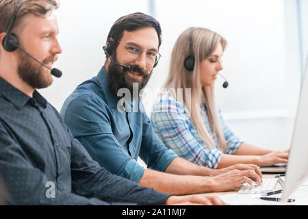 Il gruppo di specialisti nella cuffia ,lavorando sul computer. Foto Stock