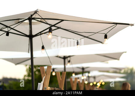 Fiera della città. caso decor. Ombrelloni bianchi su cui lampadine appendere. Foto Stock