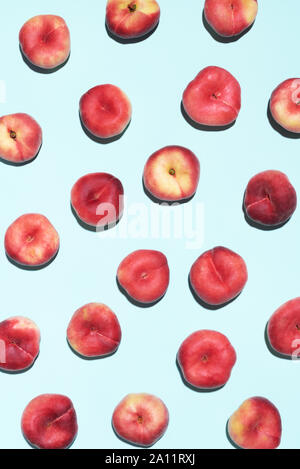 Pesche pattern pastello su sfondo blu. Cornice fatta di frutta fresca. Appartamento laico, vista dall'alto, copia dello spazio. Vegane e dieta vegetariana. Foto Stock