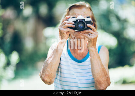 Donna anziana con un film vintage fotocamera foto Foto Stock