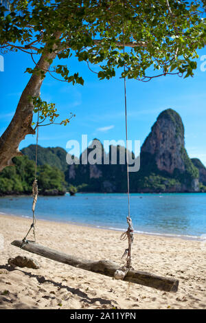 Hängeschaukel un filamento weißem blauem vor Meer und Felsenlandschaft am Railay Beach a Krabi Thailandia. Foto Stock