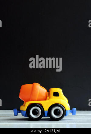 In plastica colorata betoniera su sfondo nero Foto Stock
