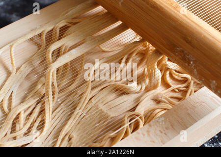 Fare spaghetti alla chitarra con un attrezzo - specialità della regione Abruzzo Foto Stock