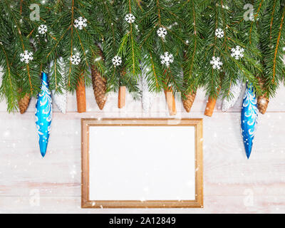 Sfondo di natale con rami di abete, fiocchi di neve, giocattoli, cannella, il cono sul telaio in legno marrone dello sfondo. Vacanze invernali concept Foto Stock