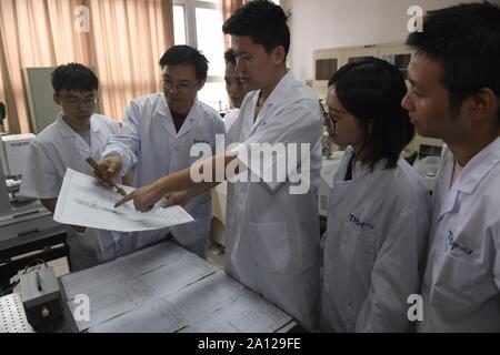 (190923) -- CHENGDU, Sett. 23, 2019 (Xinhua) -- i ricercatori dell'Università di sistemi elettronici per il controllo della scienza e della tecnologia della Cina (UESTC) discutere la struttura del getto di plasma in UESTC a Chengdu, Cina sud-occidentale della provincia di Sichuan, Sett. 19, 2019. Recentemente, i ricercatori del dipartimento di fisica e di elettronica, scuola di electronic science and engineering in UESTC hanno sviluppato con successo un nuovo dispositivo a getto di plasma dopo due anni di esperimenti scientifici. Plasma vengono eccitati mediante energia a microonde. Attraverso la progettazione di una struttura speciale per l'interno del getto a plasma e l'ugello, la l Foto Stock